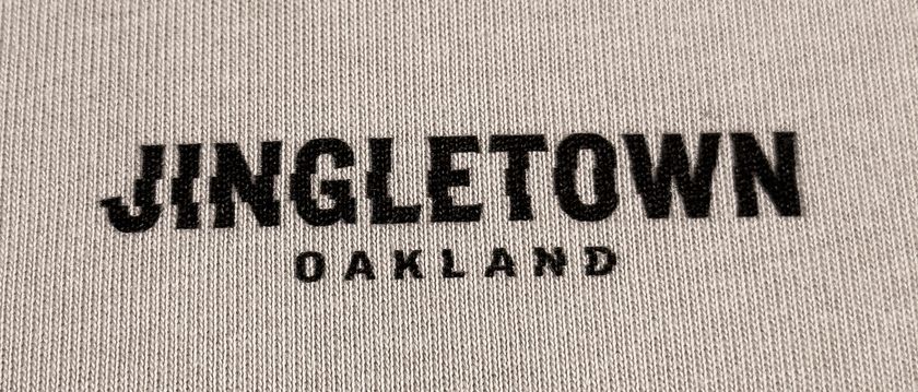 The Jingletown, Oakland wordmark printed on the tee, close up